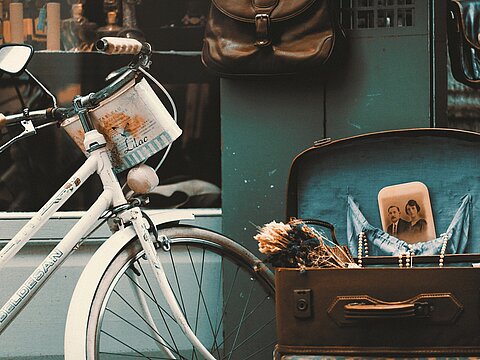 Individuelle E-Commerce-Shops – perfekt auf Ihre Produkte zugeschnitten Symbolbild für individuelle E-Commerce-Lösungen – nostalgisches Fahrrad und Koffer vor Ladenszene