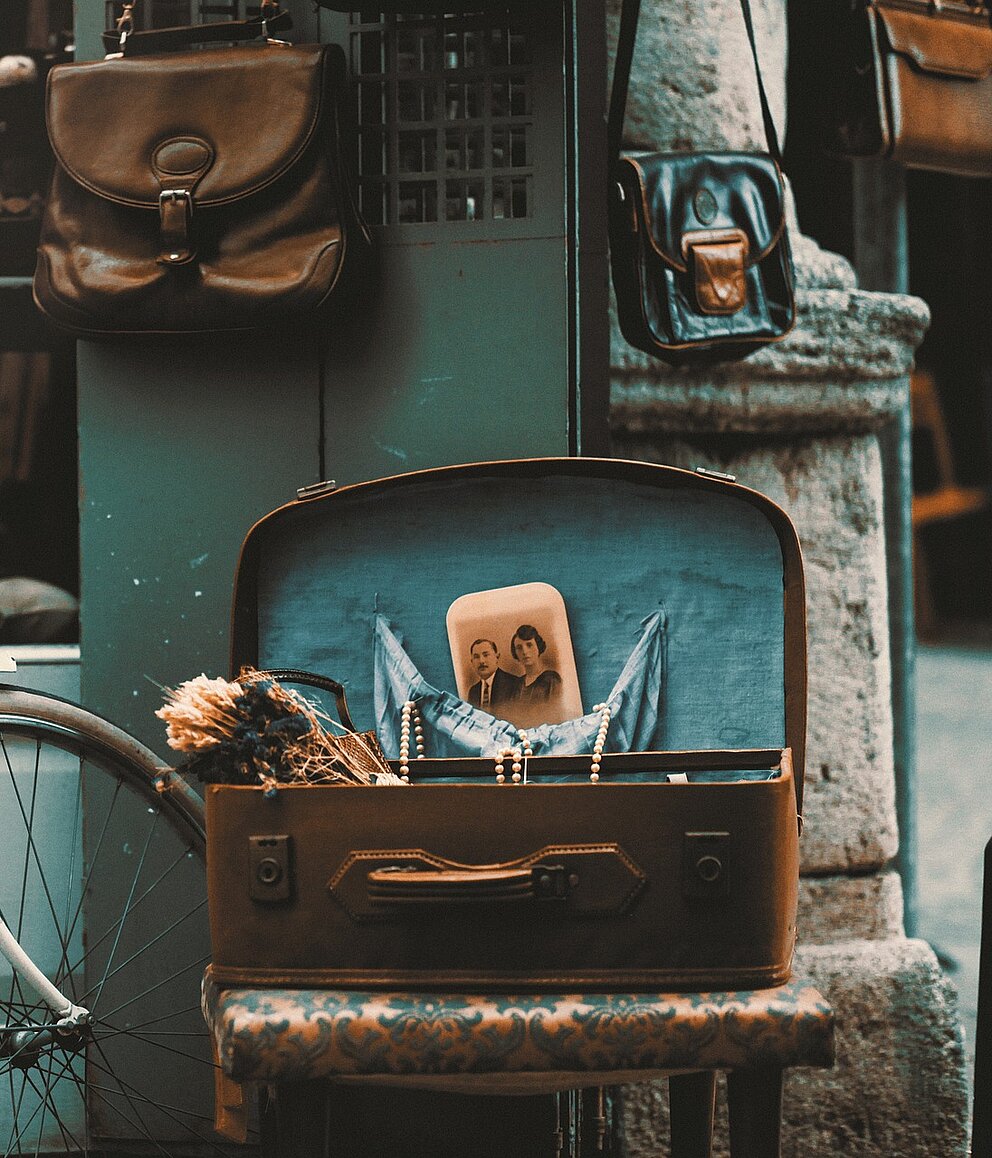Symbolbild für individuelle E-Commerce-Lösungen – nostalgisches Fahrrad und Koffer vor Ladenszene