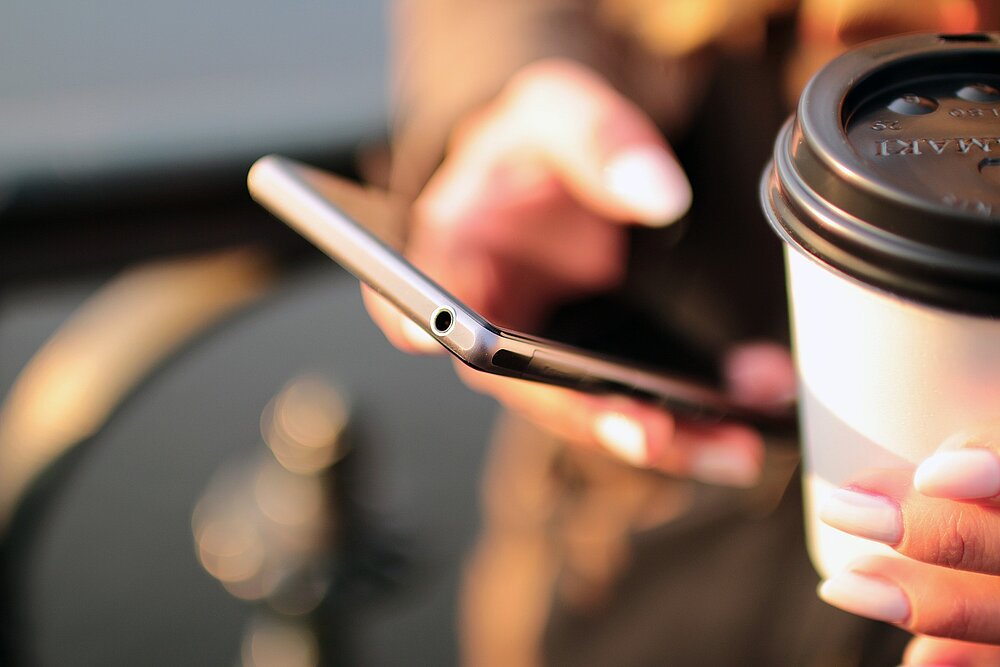 Planen Sie einen neuen Webauftritt? Wir sind nur einen Klick entfernt Hand hält Smartphone – Kontaktaufnahme mit WECOTEC GmbH leicht gemacht