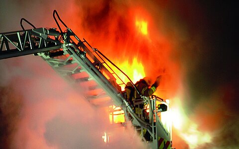 Feuerwehr mit Drehleiter bei einer Feuerbekämpfung